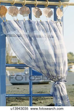 Close-up of blue+white checked voile curtain with seashell clips on window with view of harbour View Large Photo Image Stock Photography - Close-up of blue+white checked voile curtain with seashell clips on window with view of harbour. Fotosearch