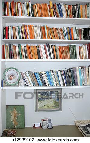 Close-up of books on white shelves above table with small telephone View Large Photo Image Stock Image - Close-up of books on white shelves above table with small telephone. Fotosearch