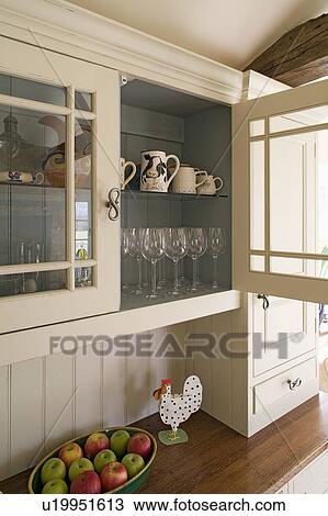 Close-up of ceramic jugs and wineglasses in cream kitchen cupboard View Large Photo Image Stock Image - Close-up of ceramic jugs and wineglasses in cream kitchen cupboard. Fotosearch