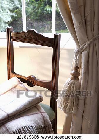 Close-up of checked blankets on chair beside cream curtain with tasseled tie-back View Large Photo Image Stock Photograph - Close-up of checked blankets on chair beside cream curtain with tasseled tie-back. Fotosearch