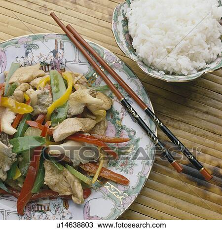 Close-up of Chinese stir-fried chicken on plate with chopsticks and bowl of rice View Large Photo Image Stock Image - Close-up of Chinese stir-fried chicken on plate with chopsticks and bowl of rice. Fotosearch