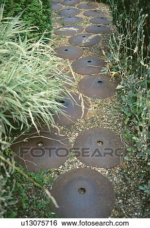 Close-up of circular metal discs creating novelty artwork on gravel path View Large Photo Image Stock Photograph - Close-up of circular metal discs creating novelty artwork on gravel path. Fotosearch