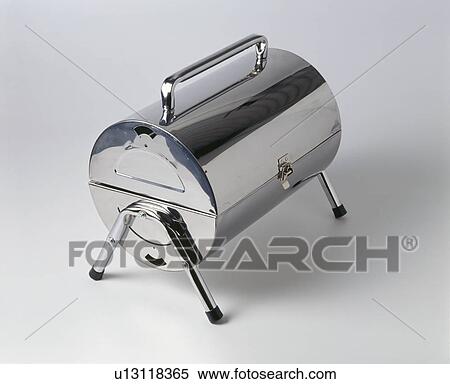 Stock Photography - Close-up of closed fold-up portable stainless-steel barbeque. Fotosearch