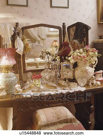 Close-up of cluttered dressing-table with triple mirror View Large Photo Image Stock Photo - Close-up of cluttered dressing-table with triple mirror. Fotosearch
