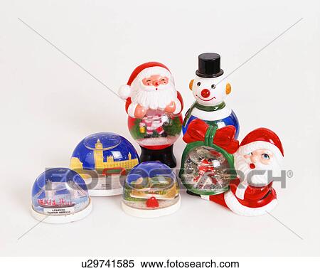 Stock Photography - Close-up of collection of globe-snowstorms with plastic Christmas Santas and snowman. Fotosearch