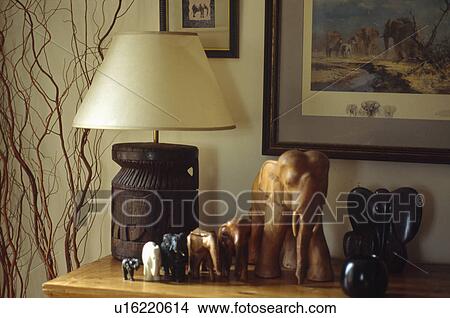 Close-up of collection of wooden elephants on table with cream lamp View Large Photo Image Picture - Close-up of collection of wooden elephants on table with cream lamp. Fotosearch