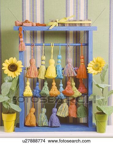 Picture - Close-up of colourful cotton tassels on blue frame. Fotosearch