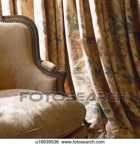 Close-up of cream upholstered Victorian chair and opulent floral curtains View Large Photo Image Stock Photograph - Close-up of cream upholstered Victorian chair and opulent floral curtains. Fotosearch