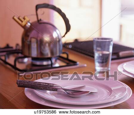Close-up of cutlery on white plate with kettle on hob in background View Large Photo Image Stock Photograph - Close-up of cutlery on white plate with kettle on hob in background . Fotosearch