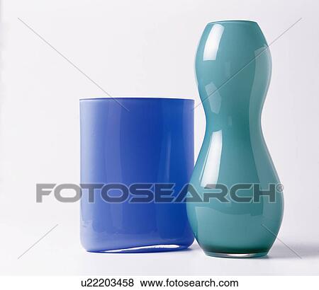 Close-up of cylindrical blue glass vase with curved turquoise glass vase View Large Photo Image Stock Photo - Close-up of cylindrical blue glass vase with curved turquoise glass vase. Fotosearch