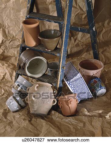 Stock Photo - Close-up of empty terracotta pots and old wooden ladder. Fotosearch