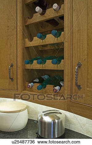 Close-up of fitted oak wine rack and small stainless steel compost bin View Large Photo Image Stock Photograph - Close-up of fitted oak wine rack and small stainless steel compost bin. Fotosearch