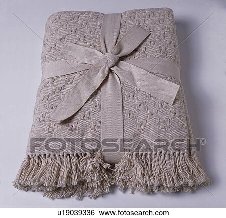 Close-up of folded beige cotton bedcover tied with matching ribbon View Large Photo Image Stock Photograph - Close-up of folded beige cotton bedcover tied with matching ribbon. Fotosearch