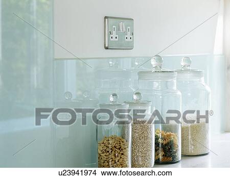 Close-up of glass storage jars and glass splashback below electric plug socket View Large Photo Image Picture - Close-up of glass storage jars and glass splashback below electric plug socket. Fotosearch