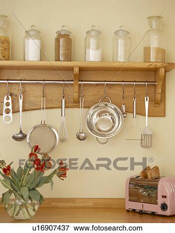 Close-up of glass storage jars on shelf above rack with metal utensils View Large Photo Image Stock Photo - Close-up of glass storage jars on shelf above rack with metal utensils. Fotosearch