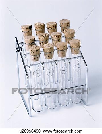 Stock Image - Close-up of glass vials with cork stoppers in stainless-steel storage frame. Fotosearch