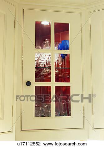 Close-up of glasses in glazed kitchen cupboard with lighting View Large Photo Image Stock Image - Close-up of glasses in glazed kitchen cupboard with lighting. Fotosearch