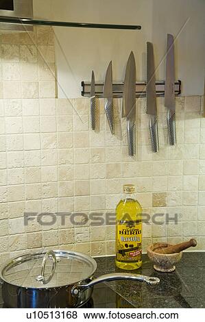 Close-up of Global stainless steel knives on rack above bottle of oil on worktop View Large Photo Image Stock Photo - Close-up of Global stainless steel knives on rack above bottle of oil on worktop. Fotosearch