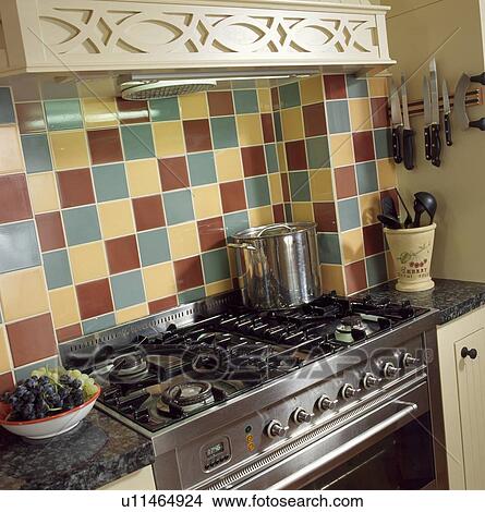 Close-up of green cream and brown wall tiles above stainless steel range oven View Large Photo Image Picture - Close-up of green cream and brown wall tiles above stainless steel range oven. Fotosearch