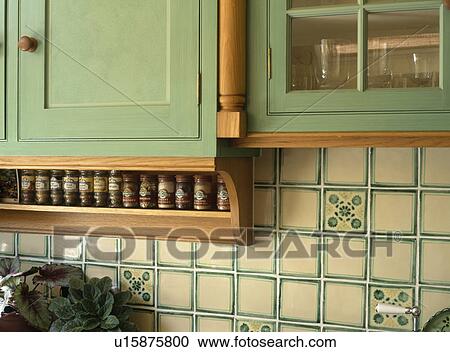 Close-up of grey+cream wall tiles below green cupboard with spice jars on rack View Large Photo Image Stock Image - Close-up of grey+cream wall tiles below green cupboard with spice jars on rack. Fotosearch