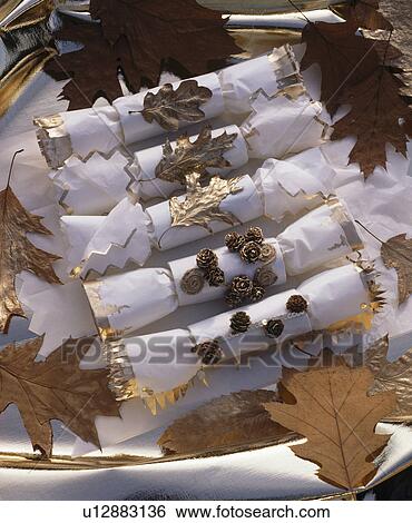 Close-up of hand-made white Christmas crackers decorated with gold leaves View Large Photo Image Stock Photograph - Close-up of hand-made white Christmas crackers decorated with gold leaves. Fotosearch