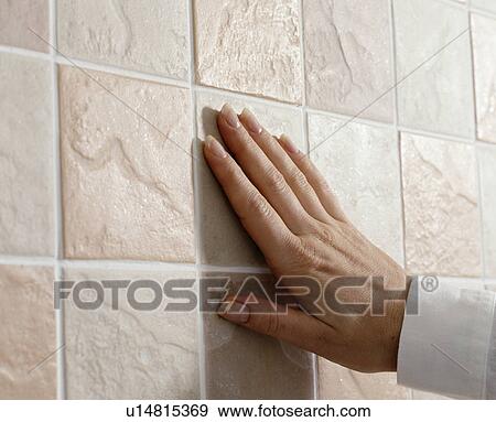 Close-up of hand on cream tiled wall View Large Photo Image Stock Photo - Close-up of hand on cream tiled wall. Fotosearch