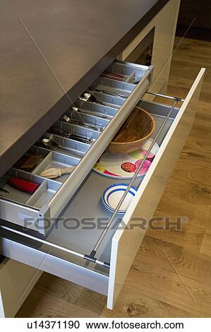 Stock Image - Close-up of kitchen drawers with stainless steel storage compartments. Fotosearch