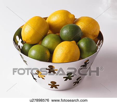 Stock Photograph - Close-up of lemons and limes in stainless steel bowl. Fotosearch