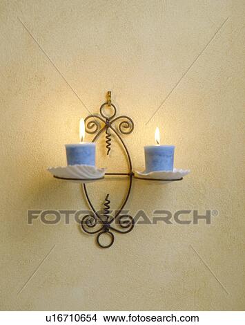 Close-up of lighted blue candles on wrought-iron wall-sconce View Large Photo Image Picture - Close-up of lighted blue candles on wrought-iron wall-sconce. Fotosearch