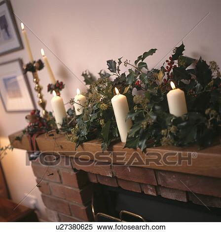 Close-up of lighted candles and fresh holly and ivy on mantelpiece View Large Photo Image Stock Photography - Close-up of lighted candles and fresh holly and ivy on mantelpiece. Fotosearch