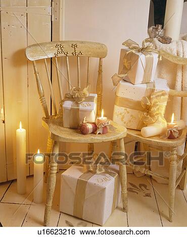 Close-up of lighted candles and gold painted chair with gift-wrapped Christmas presents View Large Photo Image Stock Photograph - Close-up of lighted candles and gold painted chair with gift-wrapped Christmas presents. Fotosearch