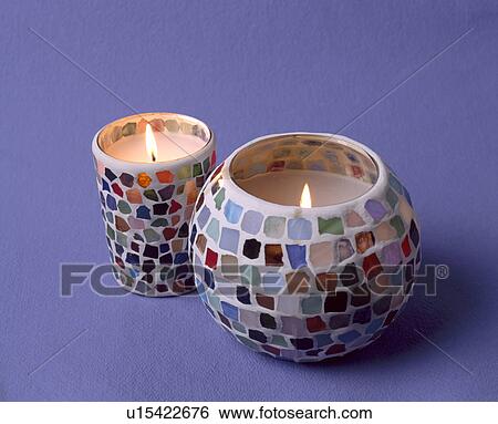 Stock Photograph - Close-up of lighted candles in glass mosaic holders. Fotosearch