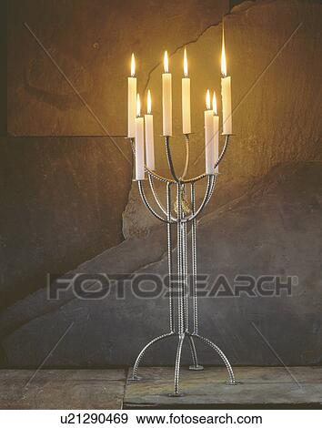 Close-up of lighted candles in metal candelabra View Large Photo Image Stock Photo - Close-up of lighted candles in metal candelabra. Fotosearch