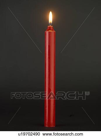 Close-up of lighted tall red candle View Large Photo Image Stock Image - Close-up of lighted tall red candle. Fotosearch