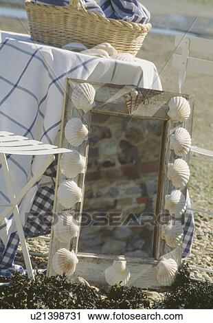 Stock Image - Close-up of mirror with seashell-decorated frame. Fotosearch