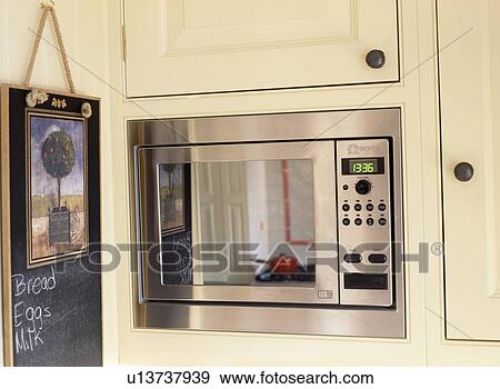 Stock Photo - Close-up of Neff microwave and kitchen noticeboard. Fotosearch