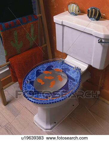 Close-up of novelty seashore-themed perspex toilet seat in red family bathroom View Large Photo Image Stock Image - Close-up of novelty seashore-themed perspex toilet seat in red family bathroom. Fotosearch