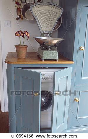 Close-up of old kitchen scales on worktop above washing machine fitted behind cupboard doors View Large Photo Image Stock Photograph - Close-up of old kitchen scales on worktop above washing machine fitted behind cupboard doors. Fotosearch
