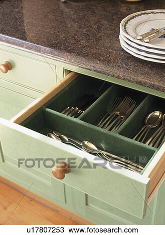 Stock Image - Close-up of open drawer with cutlery storage. Fotosearch