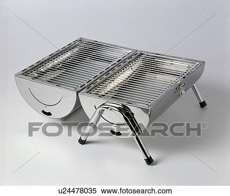 Stock Photography - Close-up of open fold-up stainless-steel portable barbeque. Fotosearch
