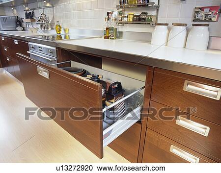 Stock Image - Close-up of open storage drawer in modern kitchen unit. Fotosearch