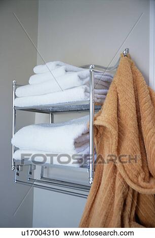 Close-up of orange bathrobe on steel shelves with pile of white towels View Large Photo Image Stock Image - Close-up of orange bathrobe on steel shelves with pile of white towels. Fotosearch