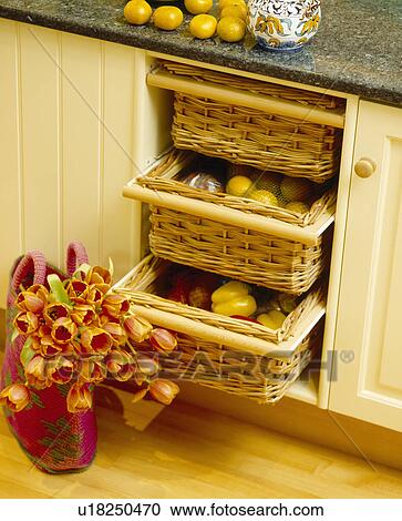 Close-up of orange tulips in basket on floor beside storage baskets in fitted unit View Large Photo Image Stock Image - Close-up of orange tulips in basket on floor beside storage baskets in fitted unit. Fotosearch