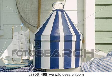 Stock Photography - Close-up of painted blue+white stiped tin box with small model sailing ship. Fotosearch