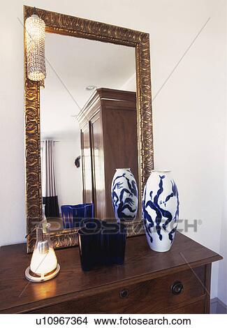 Close-up of patterned vase and lighted candle in front of large gilt mirror on dressing-table View Large Photo Image Picture - Close-up of patterned vase and lighted candle in front of large gilt mirror on dressing-table. Fotosearch