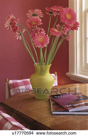 Picture - Close-up of pink gerberas in lime-green vase on wooden table. Fotosearch