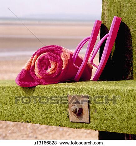 Close-up of pink plastic flip-flops and rolled pink and orange beach-towel on break-water View Large Photo Image Stock Photo - Close-up of pink plastic flip-flops and rolled pink and orange beach-towel on break-water. Fotosearch