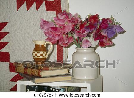 Close-up of pink sweetpeas in vase on table with books View Large Photo Image Stock Image - Close-up of pink sweetpeas in vase on table with books. Fotosearch