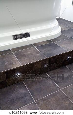 Stock Photo - Close-up of recessed lighting on split-level floor with grey ceramic tiles. Fotosearch