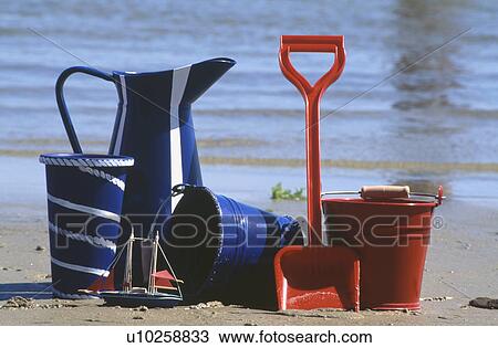 Close-up of red bucket and spade on beach with blue enamel jug and buckets View Large Photo Image Stock Image - Close-up of red bucket and spade on beach with blue enamel jug and buckets. Fotosearch